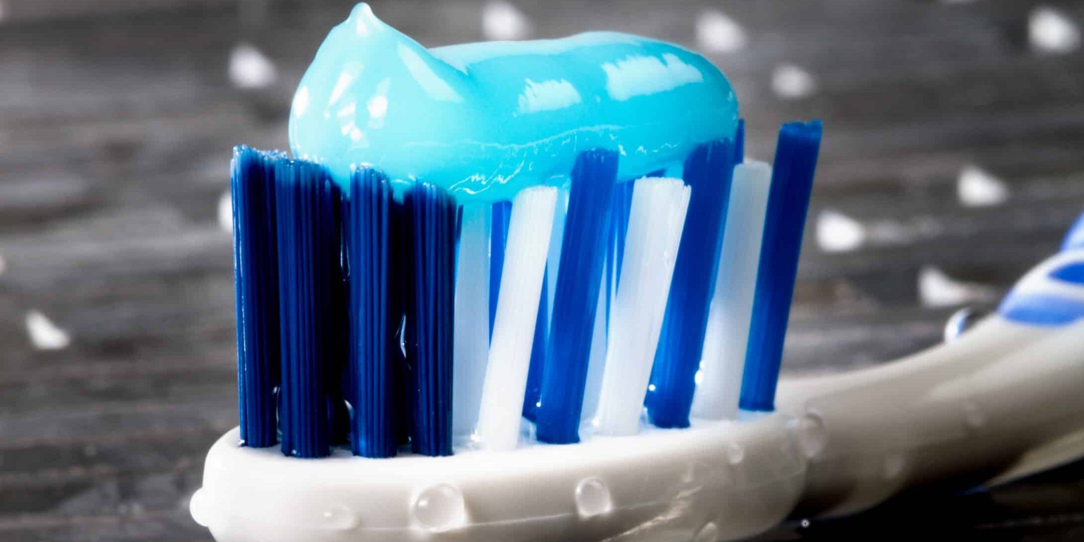 A turquoise glowing toothpaste on a toothbrush.