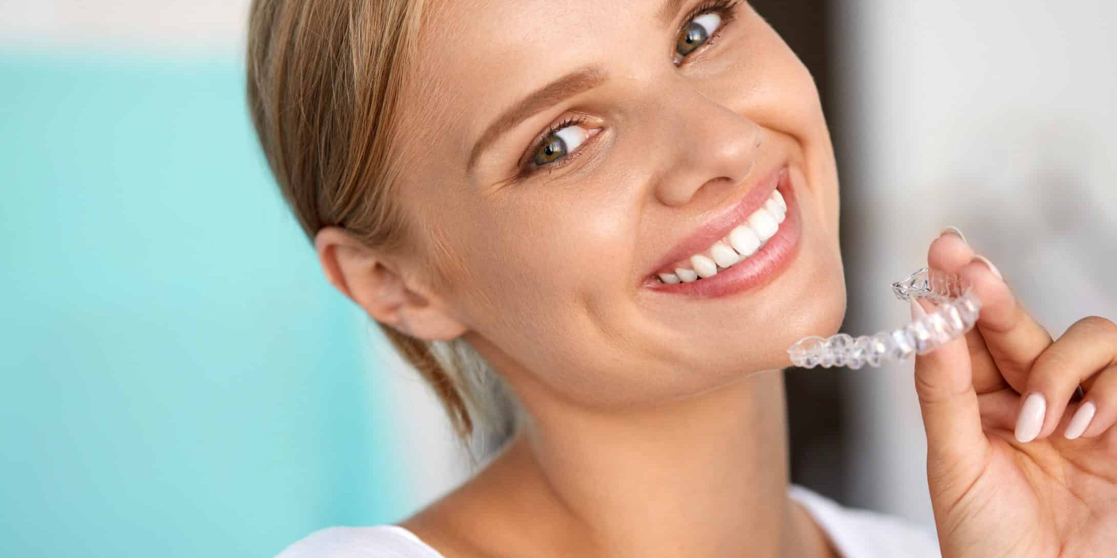 White Teeth. Closeup Portrait Of Beautiful Happy Woman With Perfect White Smile Using Teeth Whitening Tray. Smiling Girl Holding Medical Invisible Braces. Dental Health Concept. High Resolution Image